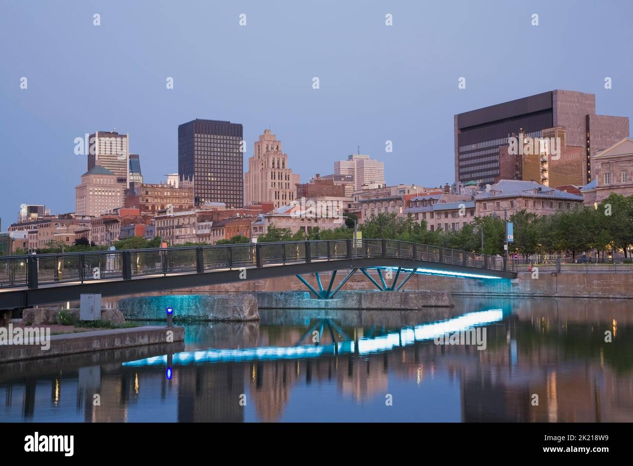 Montreal Skyline and footbridge reflected in Bonsecours Basin at dawn in spring, Old Port of Montreal, Quebec, Canada Stock Photo