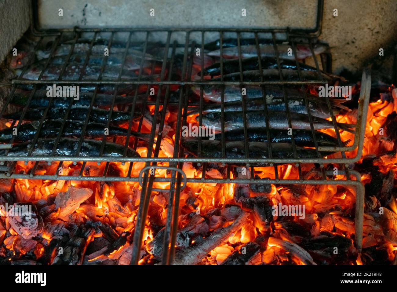 Delicious grilling sardines over the barbecue fire Stock Photo