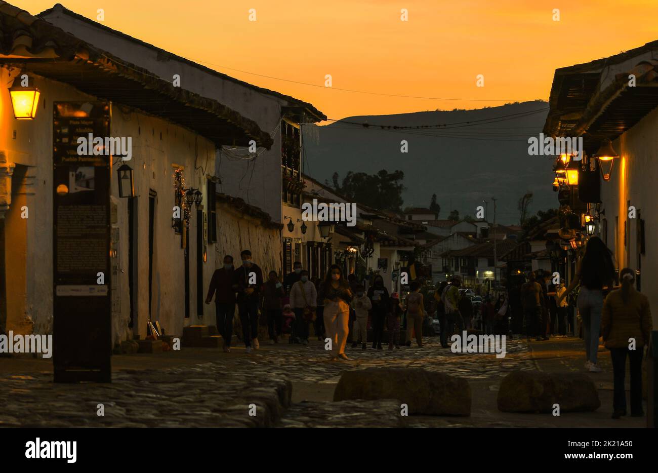 A closeup of people walking outside at sunset in Villa de Leiva, Colombia Stock Photo