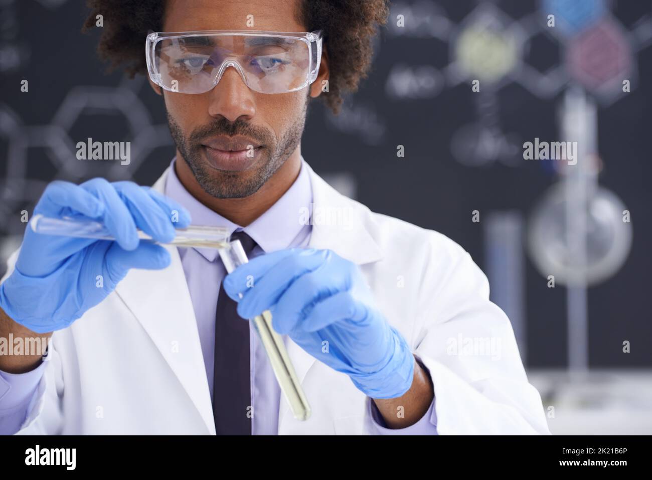 Experiments in progress. a male scientist conducting an experiment in his lab. Stock Photo