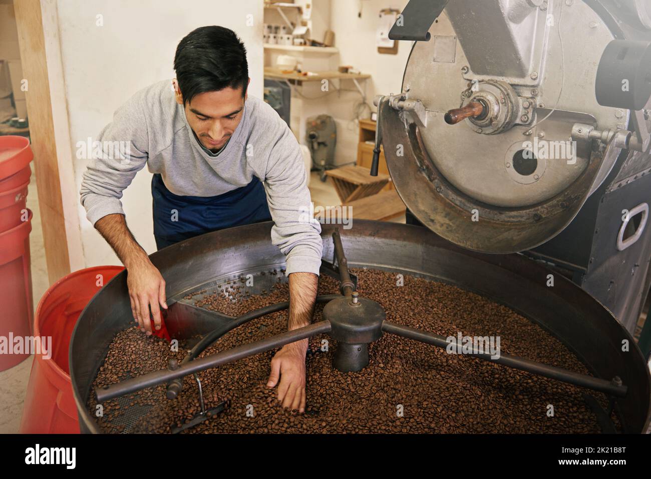 His beans are brewed to perfection. a young man grinding and roasting