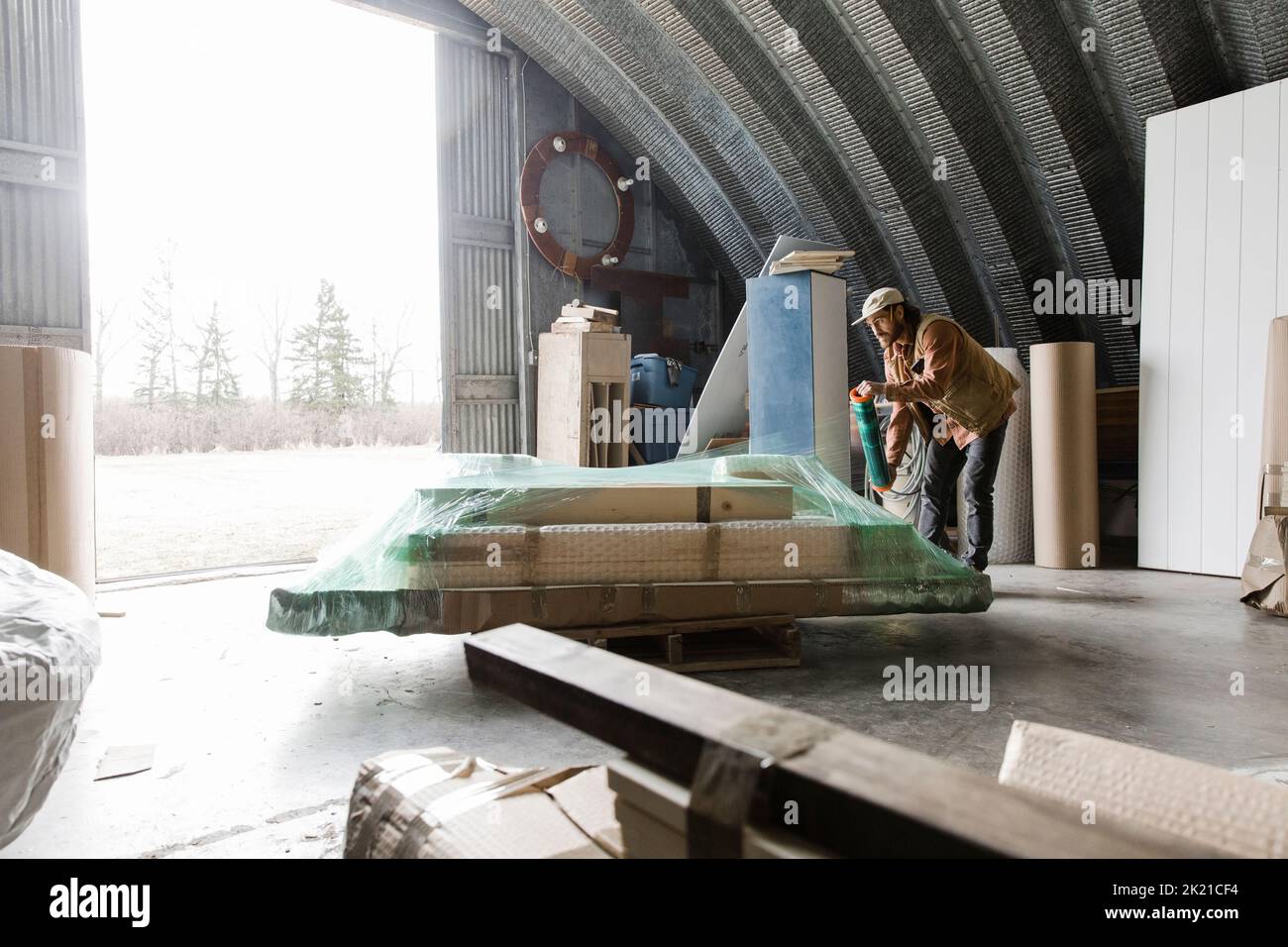 Male carpenter shrink wrapping packages in Stock Photo Alamy