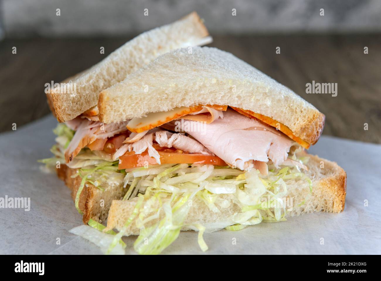 Lunch is served with a loaded smoked turkey sandwich overflowing between slices of sourdough toast. Stock Photo