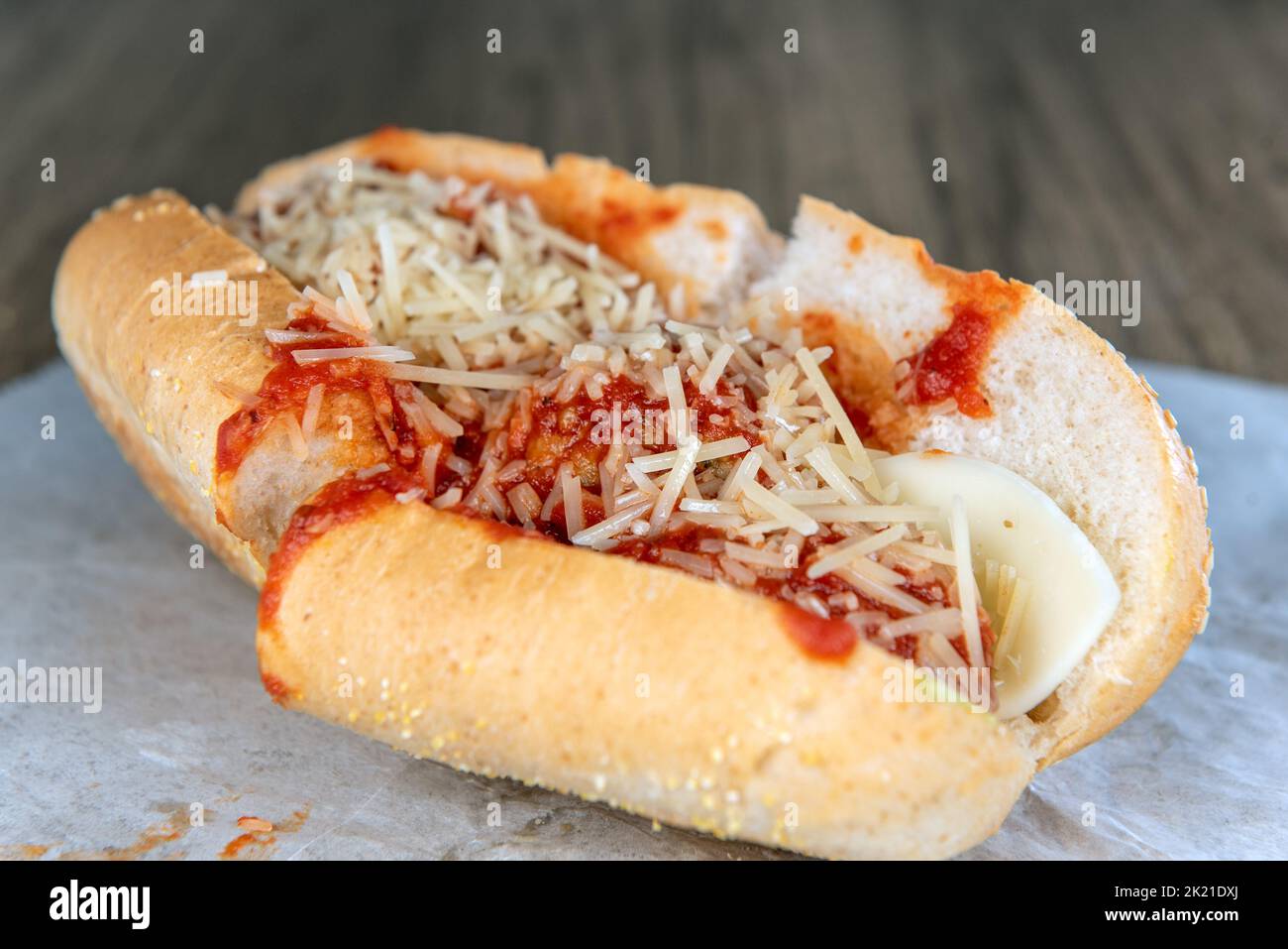 Lunch is served with a loaded meatball sandwich overflowing with provolone cheese. Stock Photo
