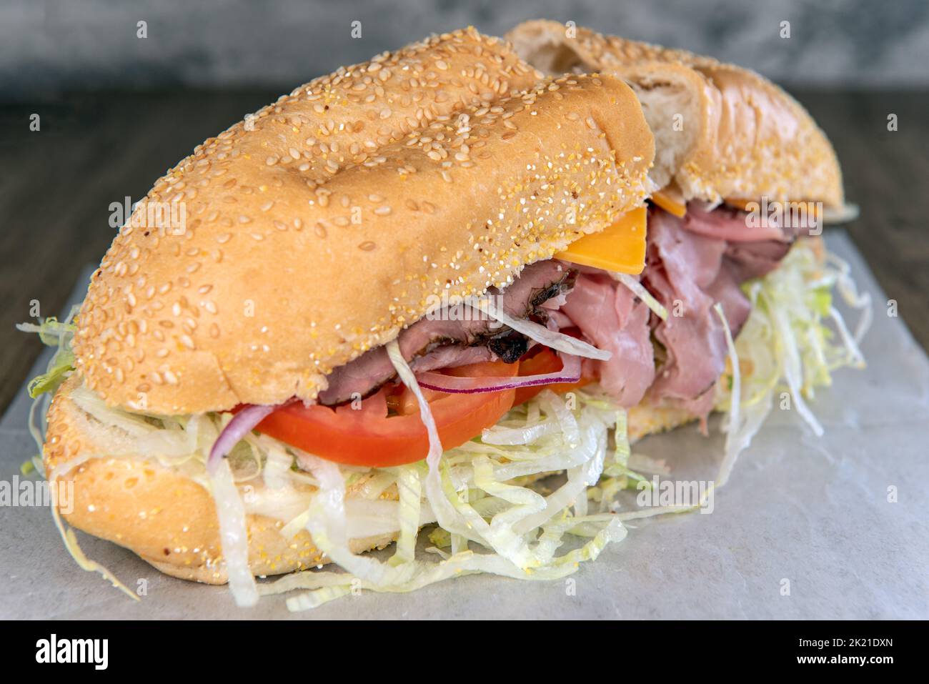 Lunch is served with a loaded roast beef and ranch sandwich overflowing with romaine lettuce. Stock Photo