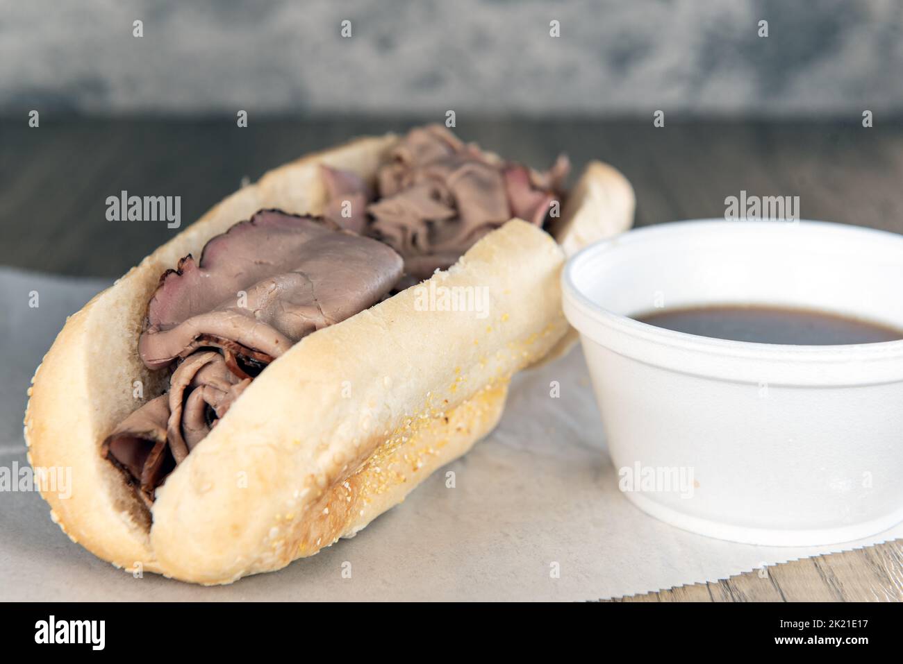 Lunch is served with a loaded roast beef french dip sandwich with auju sauce for dipping. Stock Photo