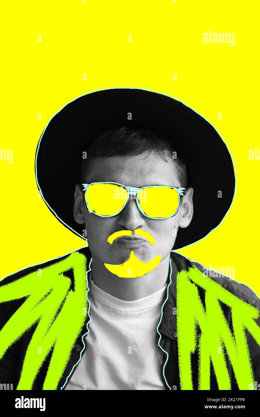 Funny art man. Smiling fashion man. Portrait of handsome smiling stylish hipster model. Man in sunglasses and hat. Fashion male on yellow background. Stock Photo