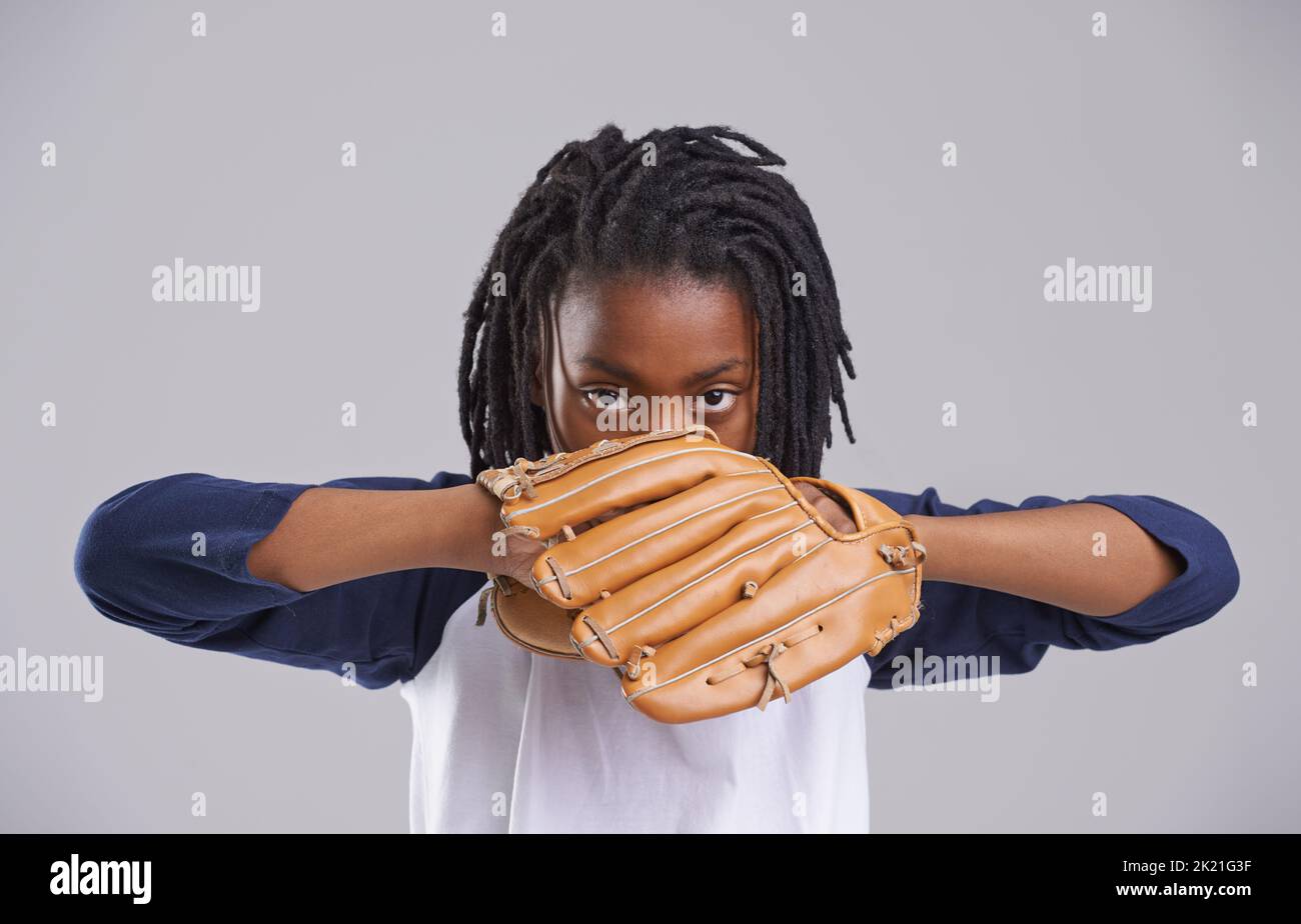 Fall into my hands. Studio shot of a young boy with baseball gear. Stock Photo