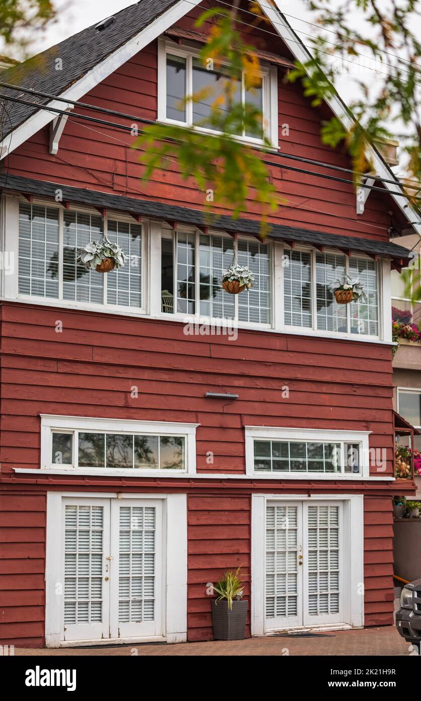 Wooden red house in countryside of Canada. Facade of a colorful house