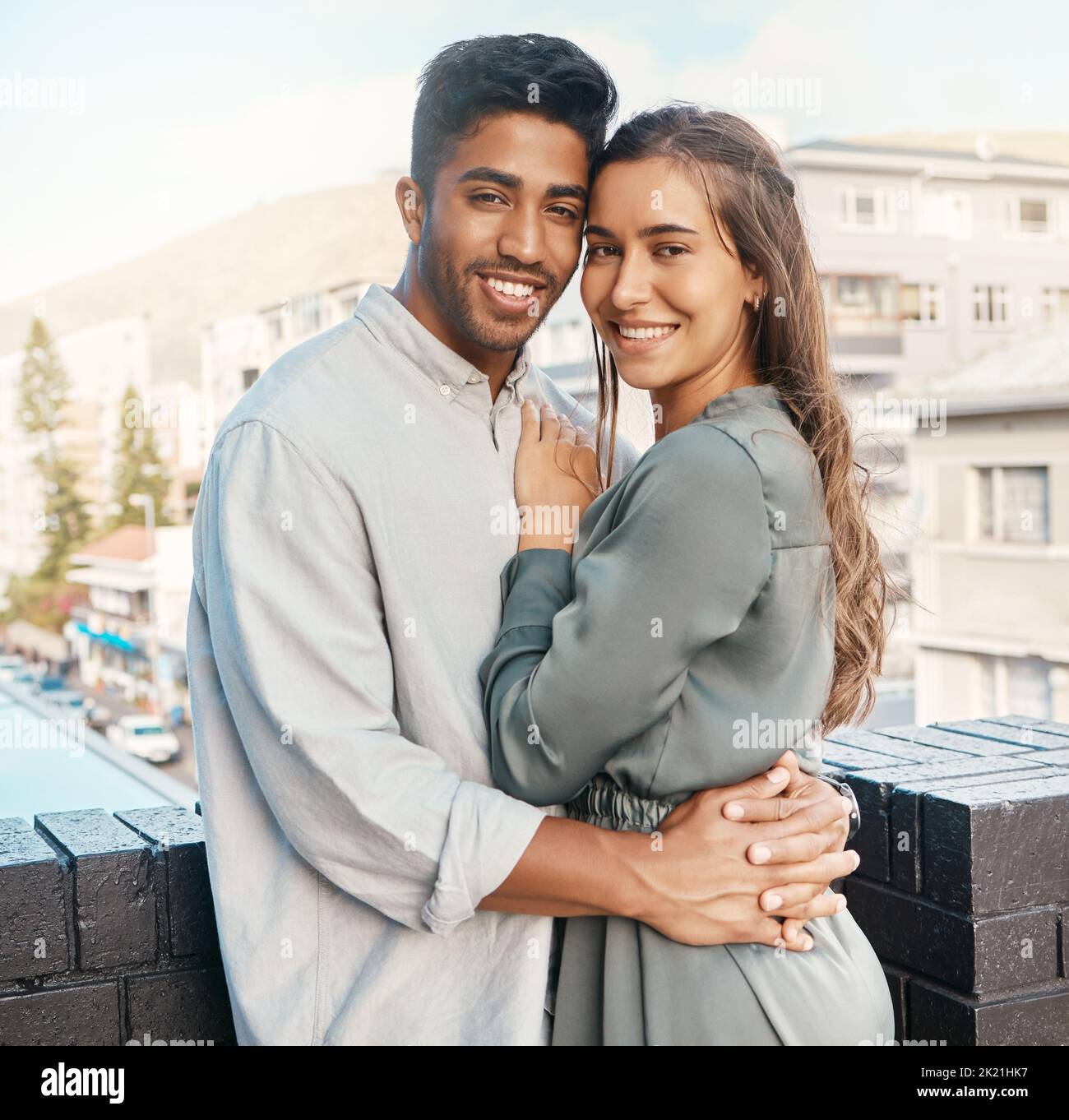 Love, couple and travel with a man and woman tourist hugging on a balcony in a foreign city together. Romance, dating and diversity with a young male Stock Photo