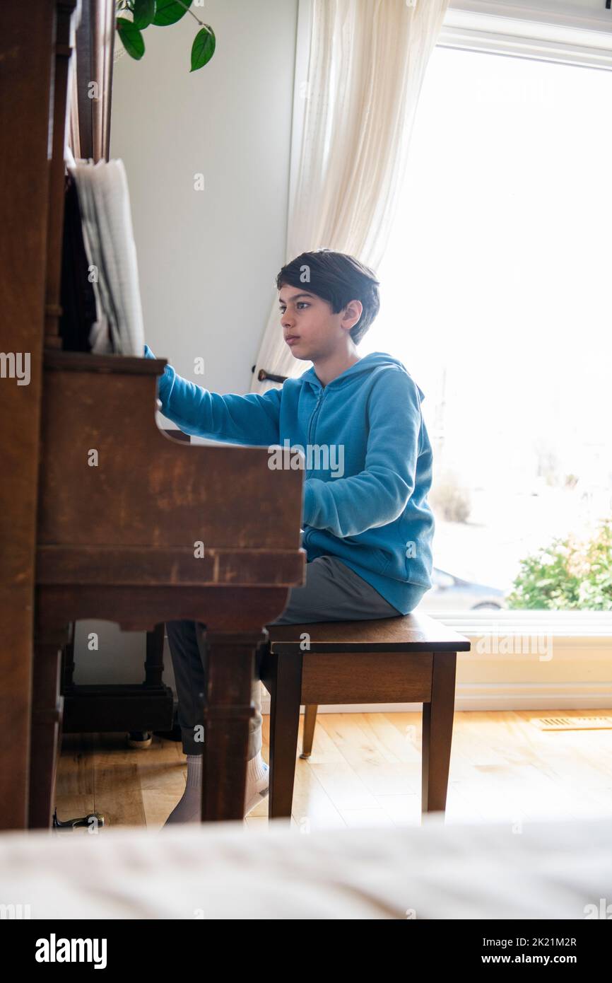Boy playing piano at home Stock Photo Alamy
