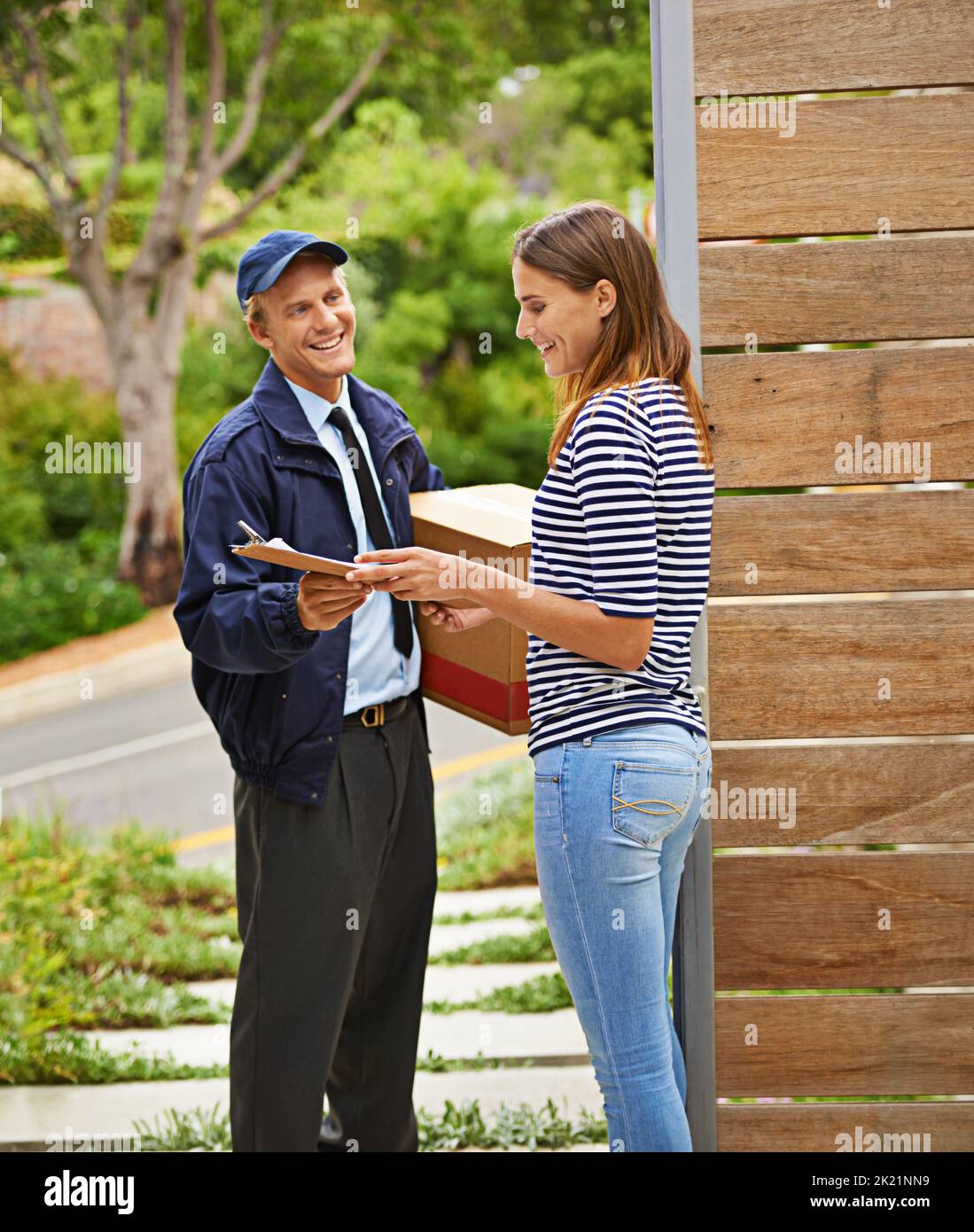 Service with a smile. a male courier delivering a package to a woman at her home. Stock Photo