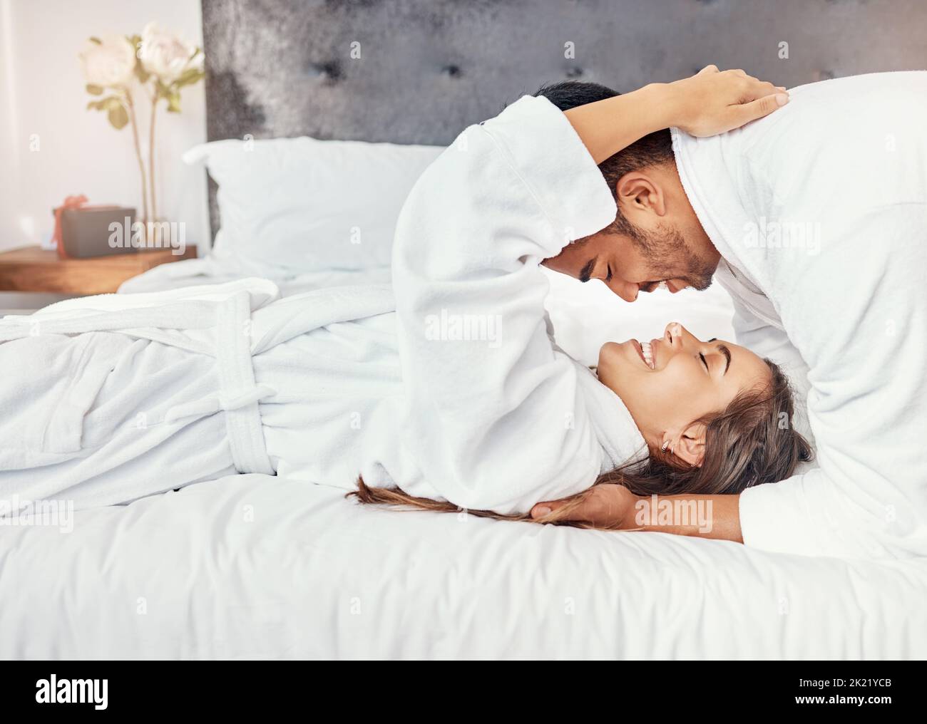 Couple holiday, hotel bedroom and happy on luxury vacation for wedding celebration, smile for love on bed and happiness hug together in house. Man and Stock Photo