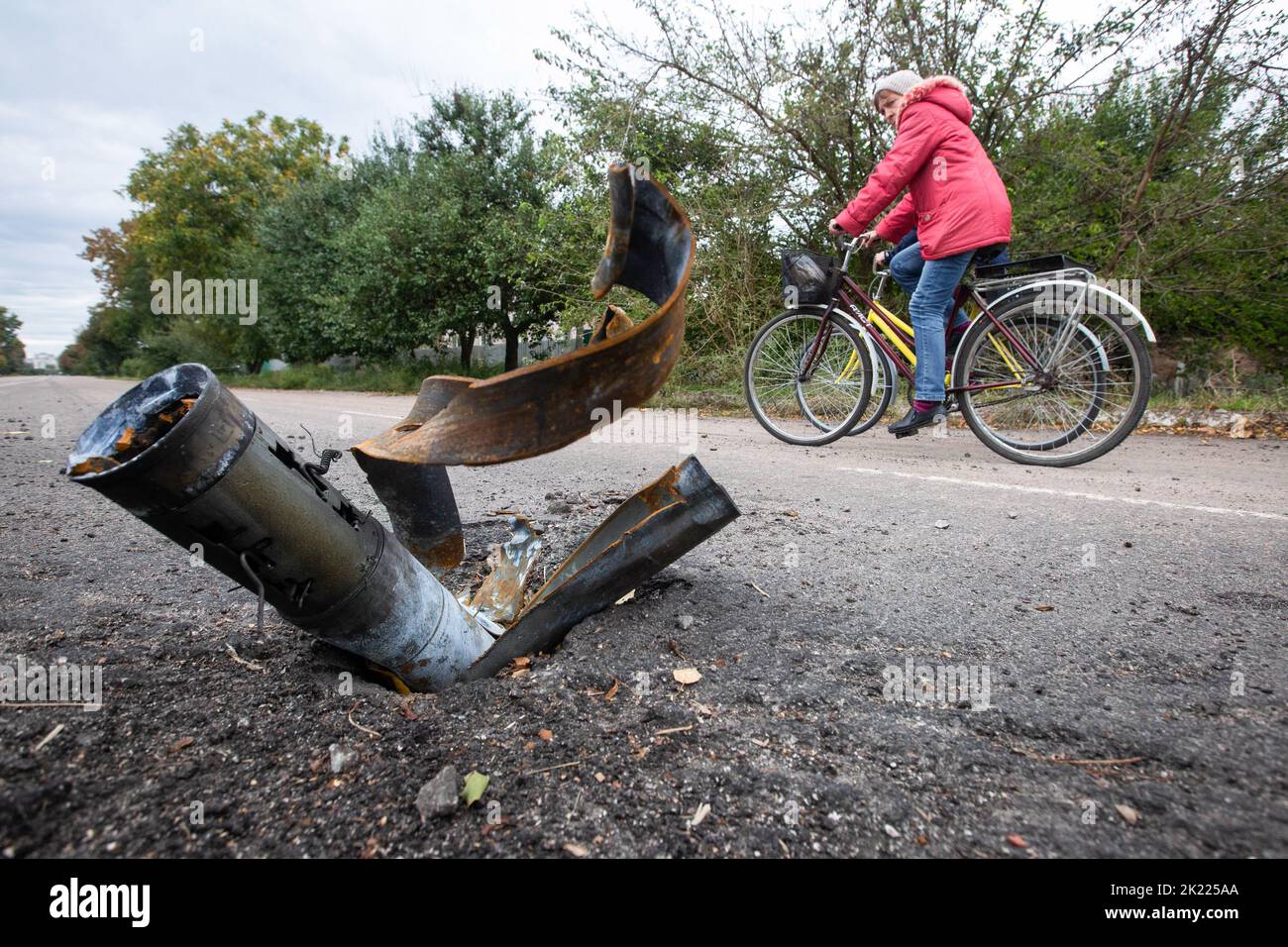 Balakliia, Ukraine, 20 Sept 2022, Local people ride bikes past an