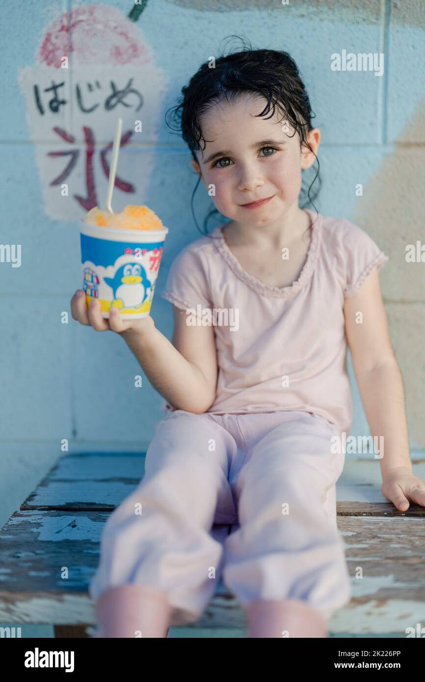 Young girl with cup of cup of kakigori shaved ice in Okinawa, Japan Stock Photo