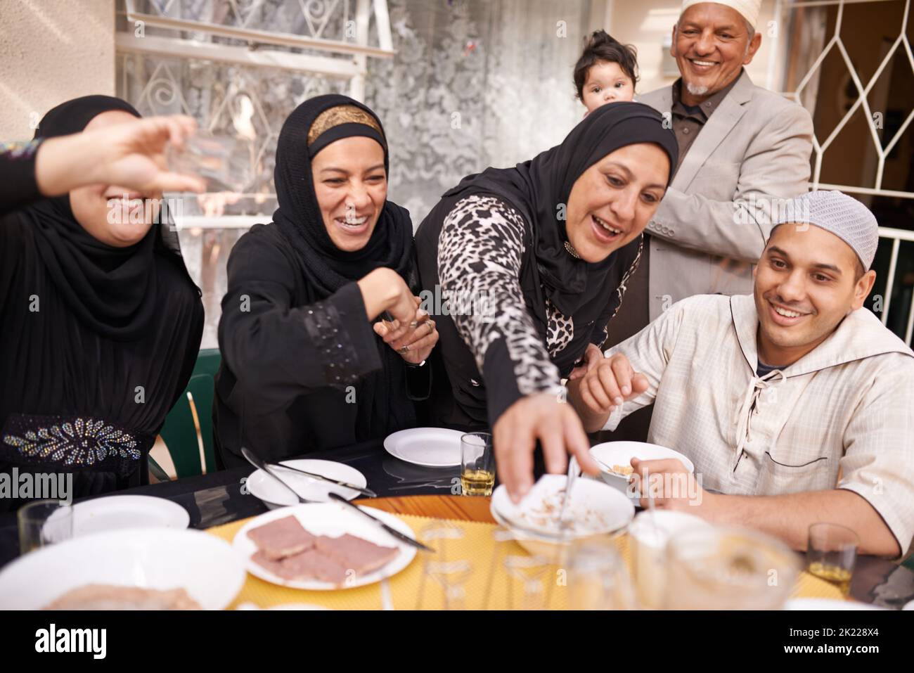 I made enough for everyone. a muslim family eating together. Stock Photo