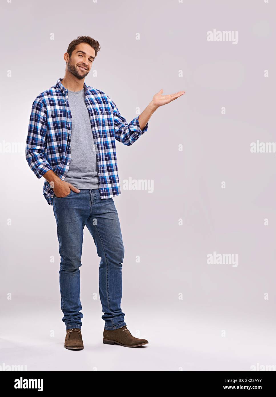 Check it out. Studio shot of a handsome man showing you copyspace against a gray background. Stock Photo