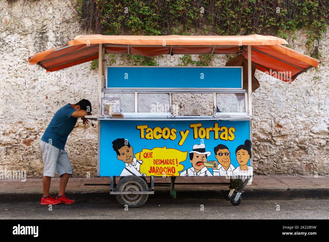 Street vendor with his head down resting on a taco cart. In the Yucatan
