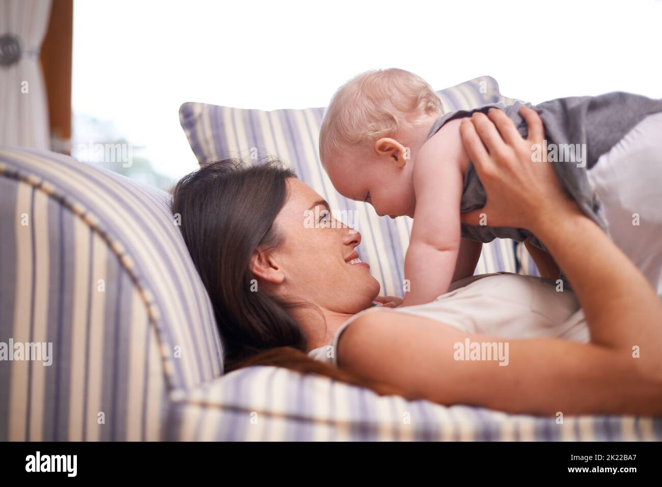 Making time for my little man. an attractive young woman and her baby girl lying on the sofa. Stock Photo