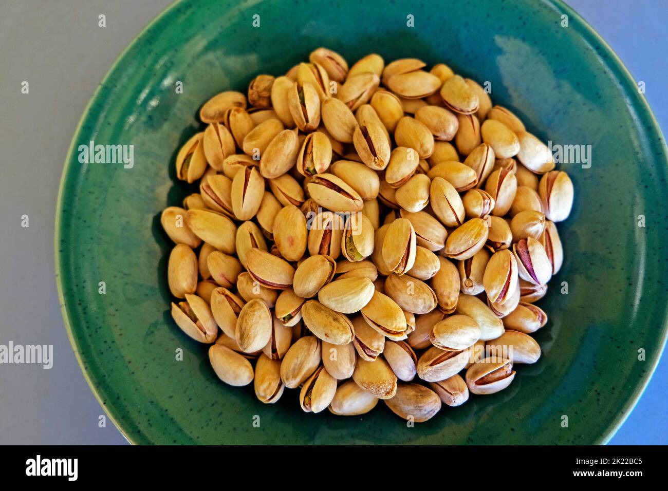 Pistachio nuts on a jade green plate Stock Photo