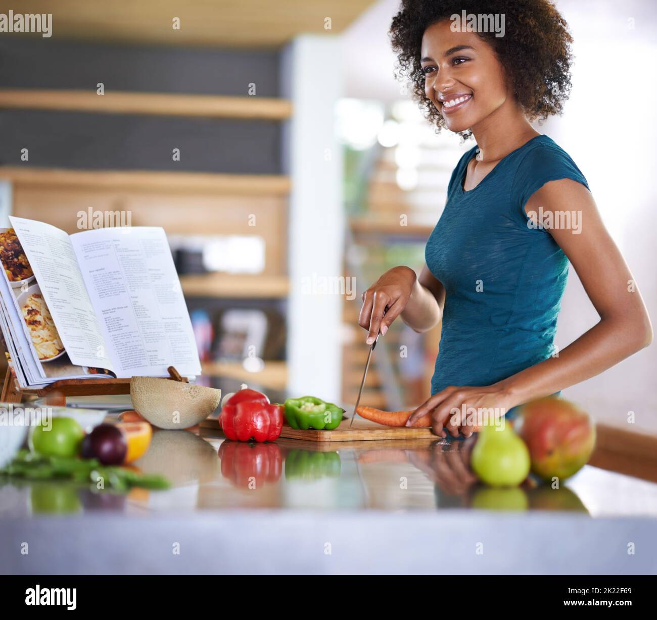 Creating a delicious dish from scratch. A young woman cooking from a ...
