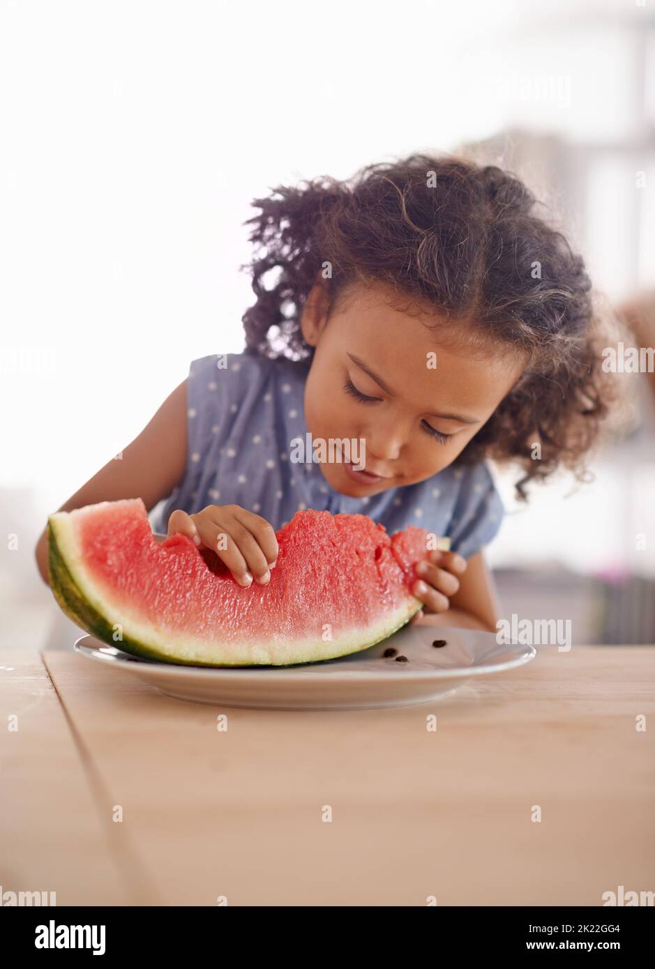 So...many...seeds. a cute little girl eating watermelon at a table