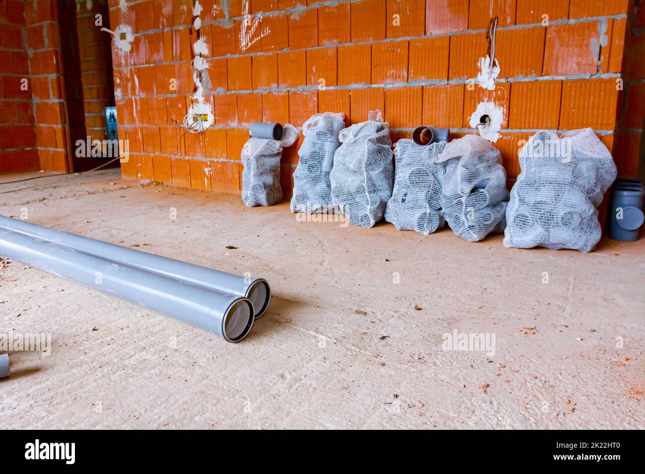 Stack of arranged parts of new grey plumbing sewer pipes elbows placed