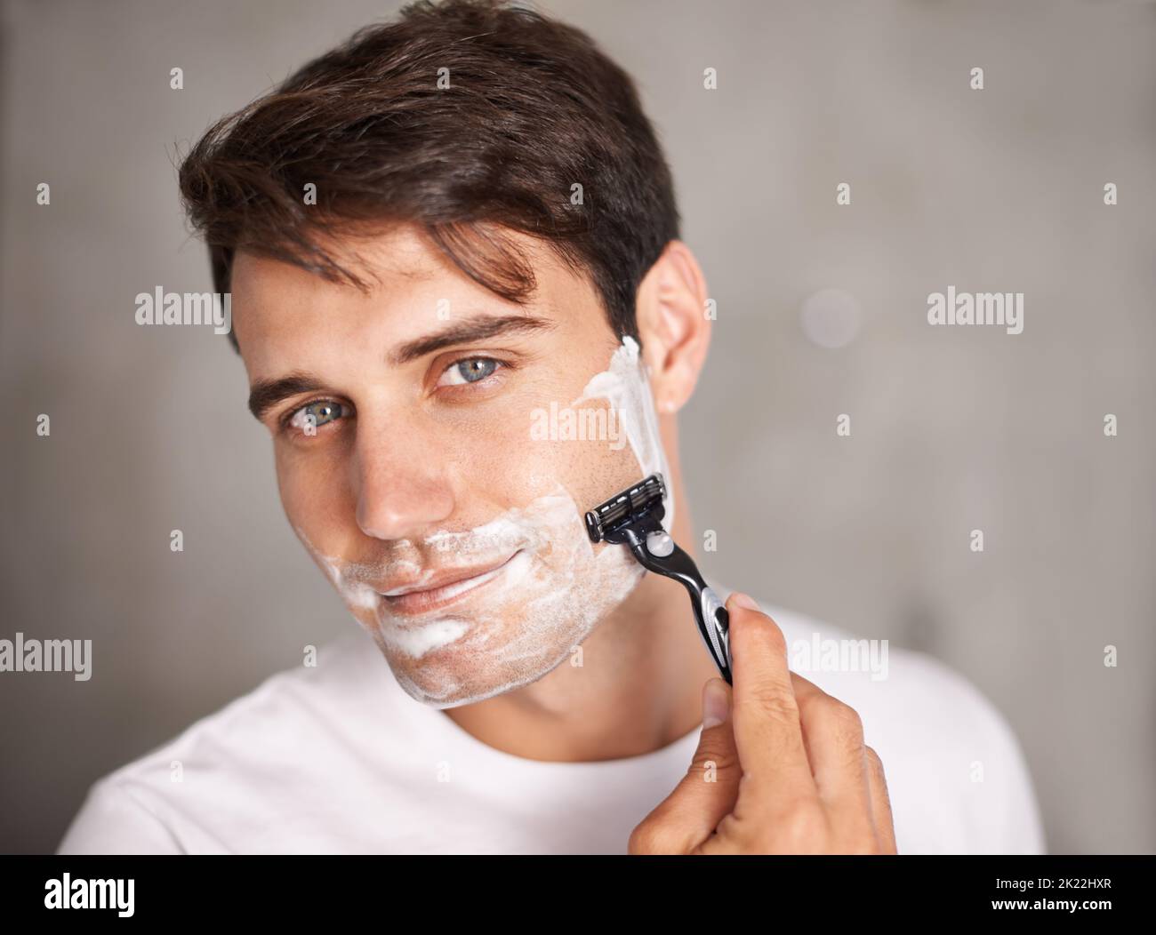 Cleaning up and looking great. Portrait shot of a handsome young man removing his facial hair. Stock Photo