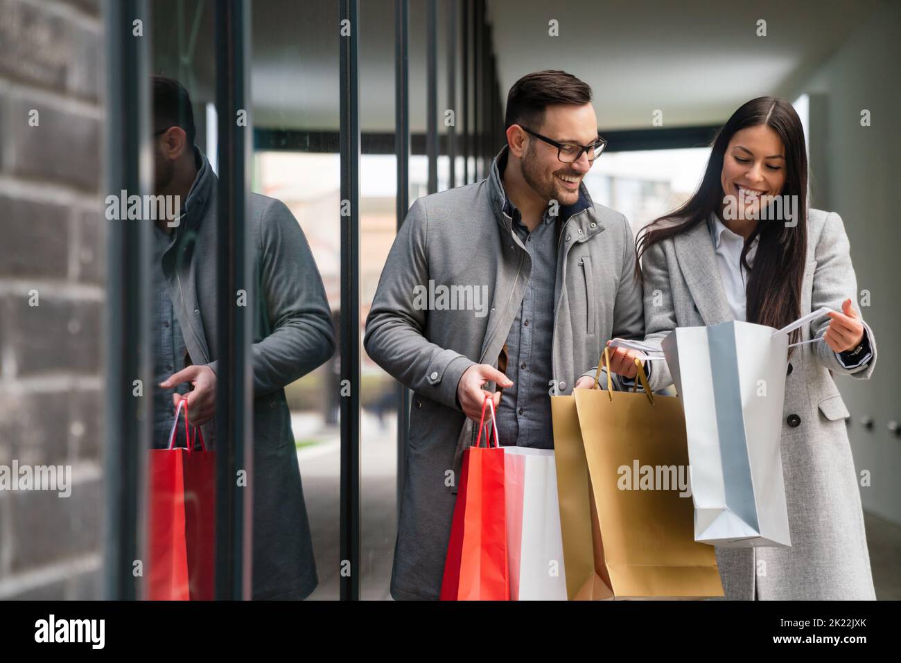 Beautiful young loving couple carrying bags and enjoying shopping together. Stock Photo