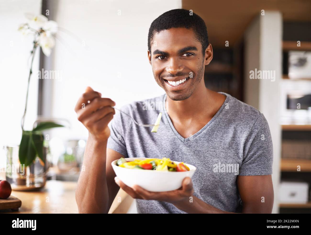 Healthy eating is a priority for me. Indoor shot of a gorgeous young black man showing off his fruit salad. Stock Photo