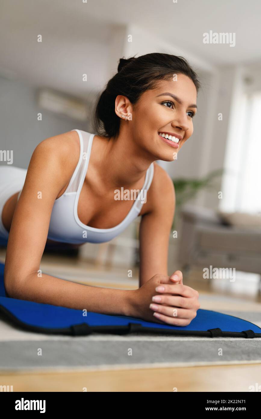 Sporty beautiful woman exercising at home to stay fit Stock Photo