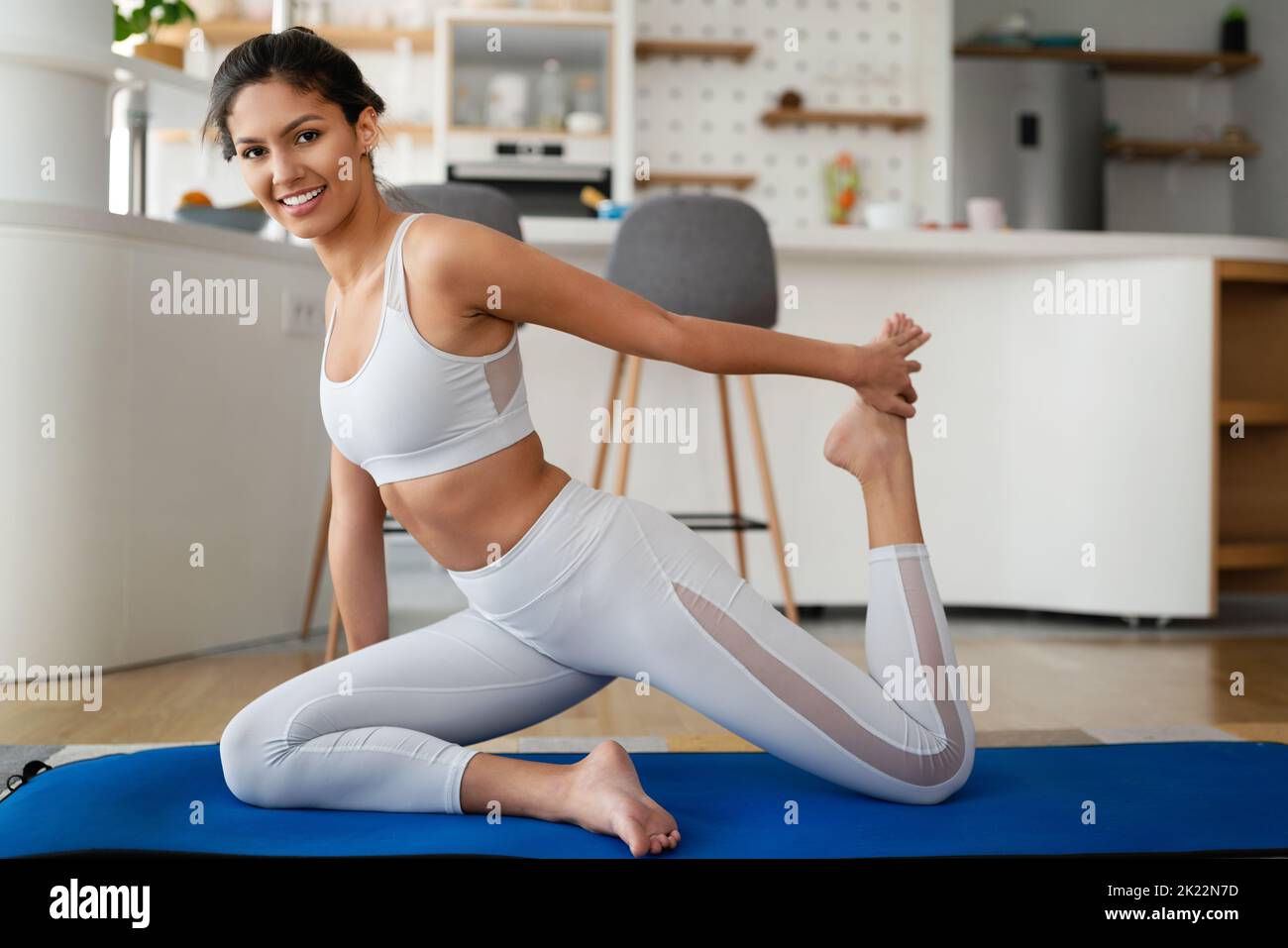 Stay at home. Fitness at home during quarantine. Young attractive woman in sportswear training Stock Photo
