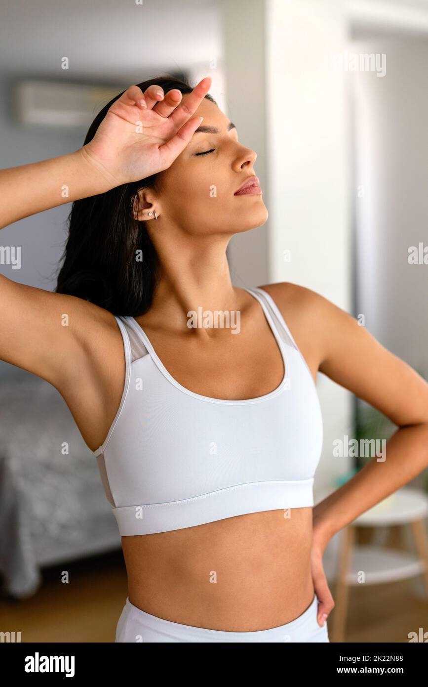 Tired fitness woman relaxing after exercise at home. Sport people concept Stock Photo