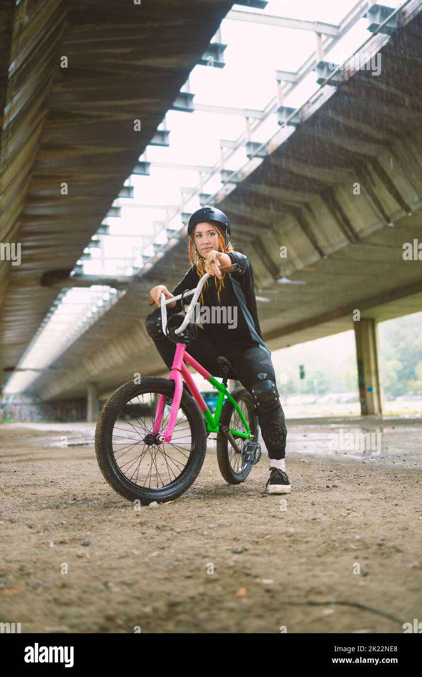 Young active woman siting on the freestyle bike wearing helmet Stock Photo