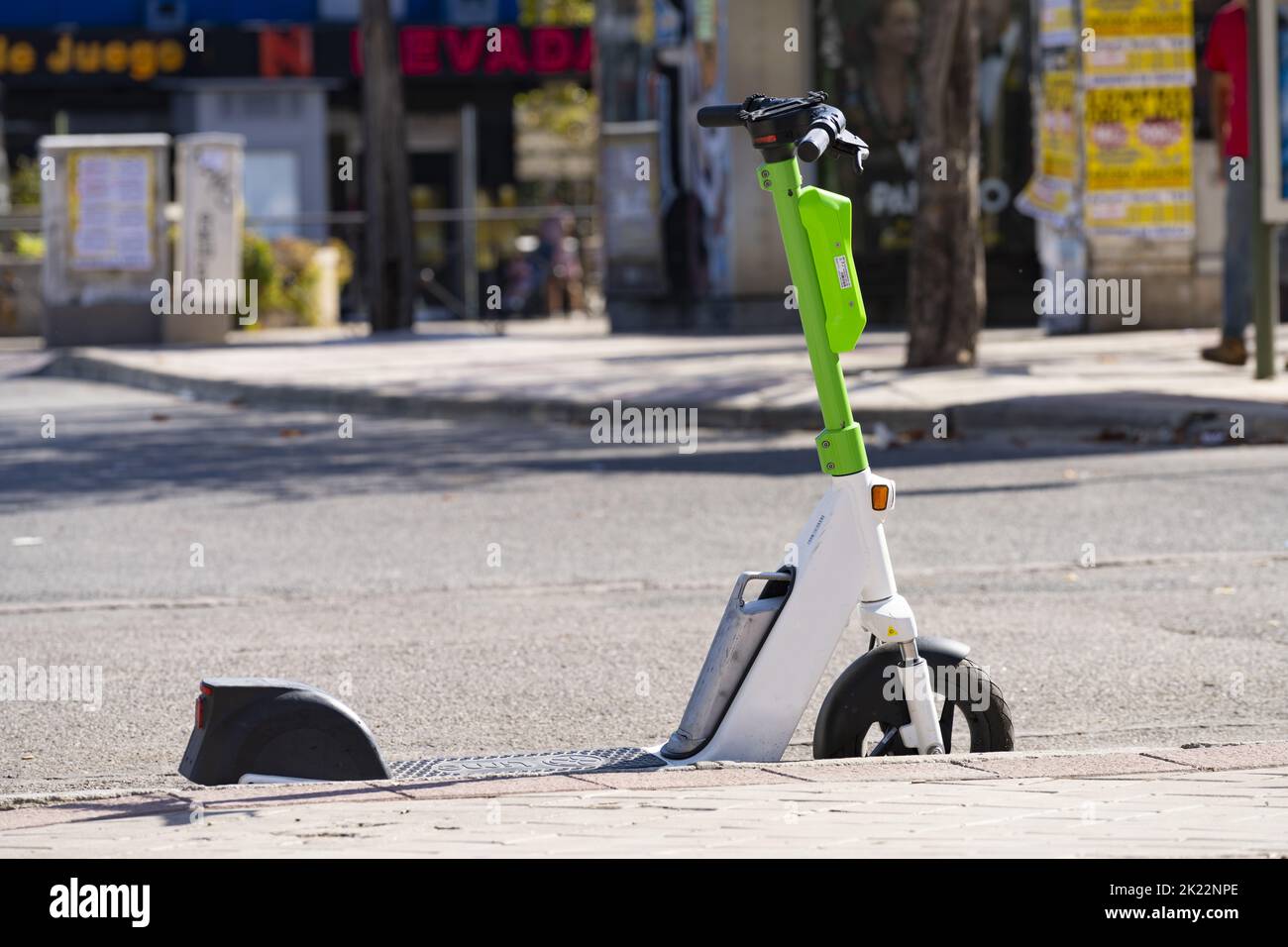 an electric push scooter parked on the side of the street in the city center Stock Photo