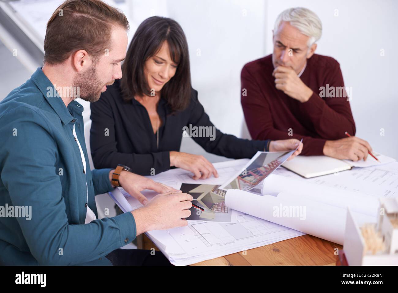 First look at the 3D designs. three architects working on a new building design. Stock Photo
