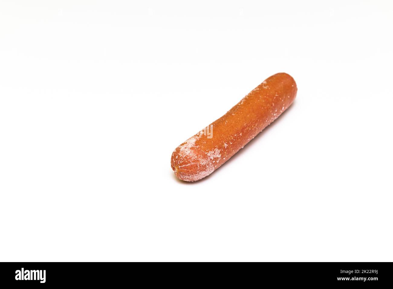 frozen sausage with traces of frost on a white background. hot dog