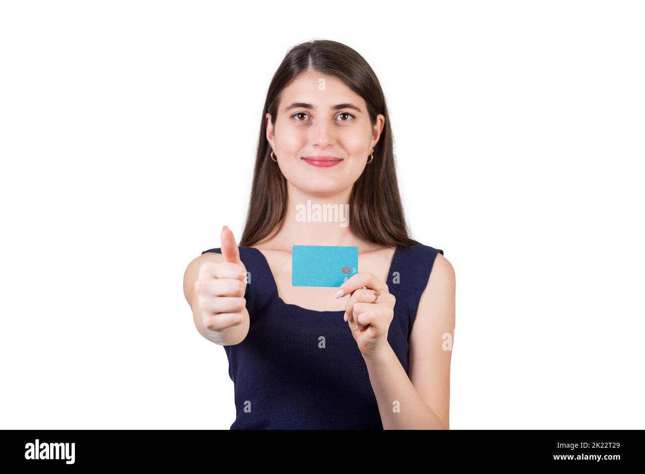 Cheerful young woman showing thumb up positive gesture while holding a credit card in other hand, isolated on white background with copy space. Approv Stock Photo