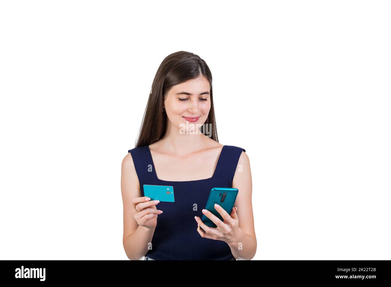 Cheerful young woman using her smartphone while holding a credit card in other hand, isolated on white background with copy space. Internet mobile ban Stock Photo