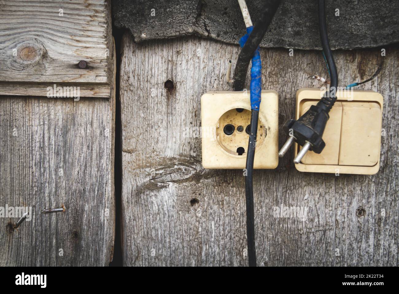 Old socket. Switch and socket. Broken electrical appliances. Non-working tool. Dangerous wires. Stock Photo