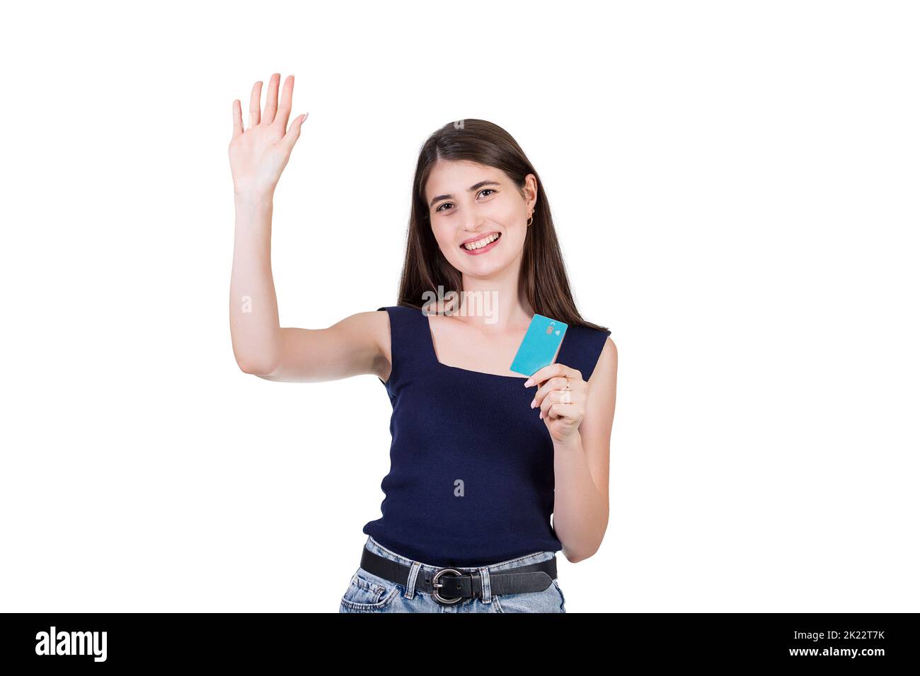 Excited young woman greets lifting hand up, highfive gesture while holding a credit card in hand, isolated on white background with copy space. Girl c Stock Photo