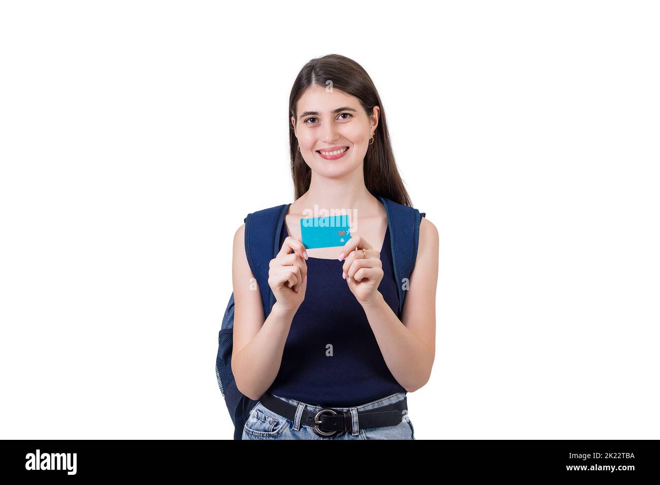 Joyful student girl with a backpack showing a credit card to camera, isolated on white background with copy space. Contented young woman advertising h Stock Photo