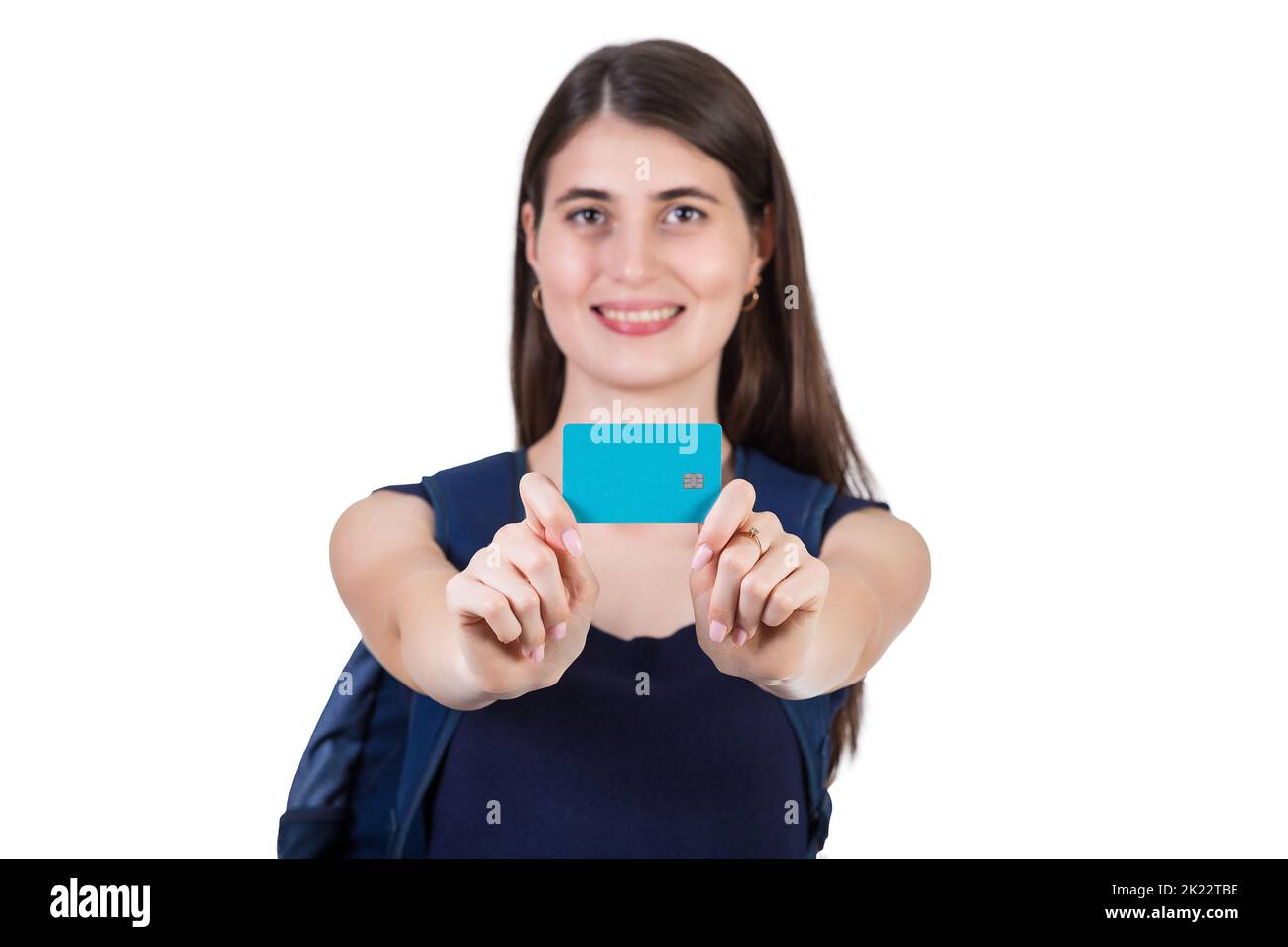 Close up cheerful student girl with a backpack presents a credit card to camera, isolated on white background with copy space. Contented young woman a Stock Photo