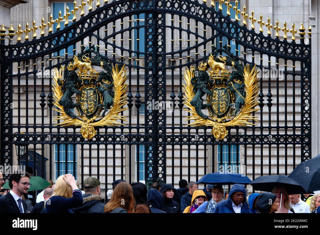 Royal crests on the gates of Buckingham Palace over the heads of vistors and mourners following the death of Queen Elizabeth II, London Stock Photo