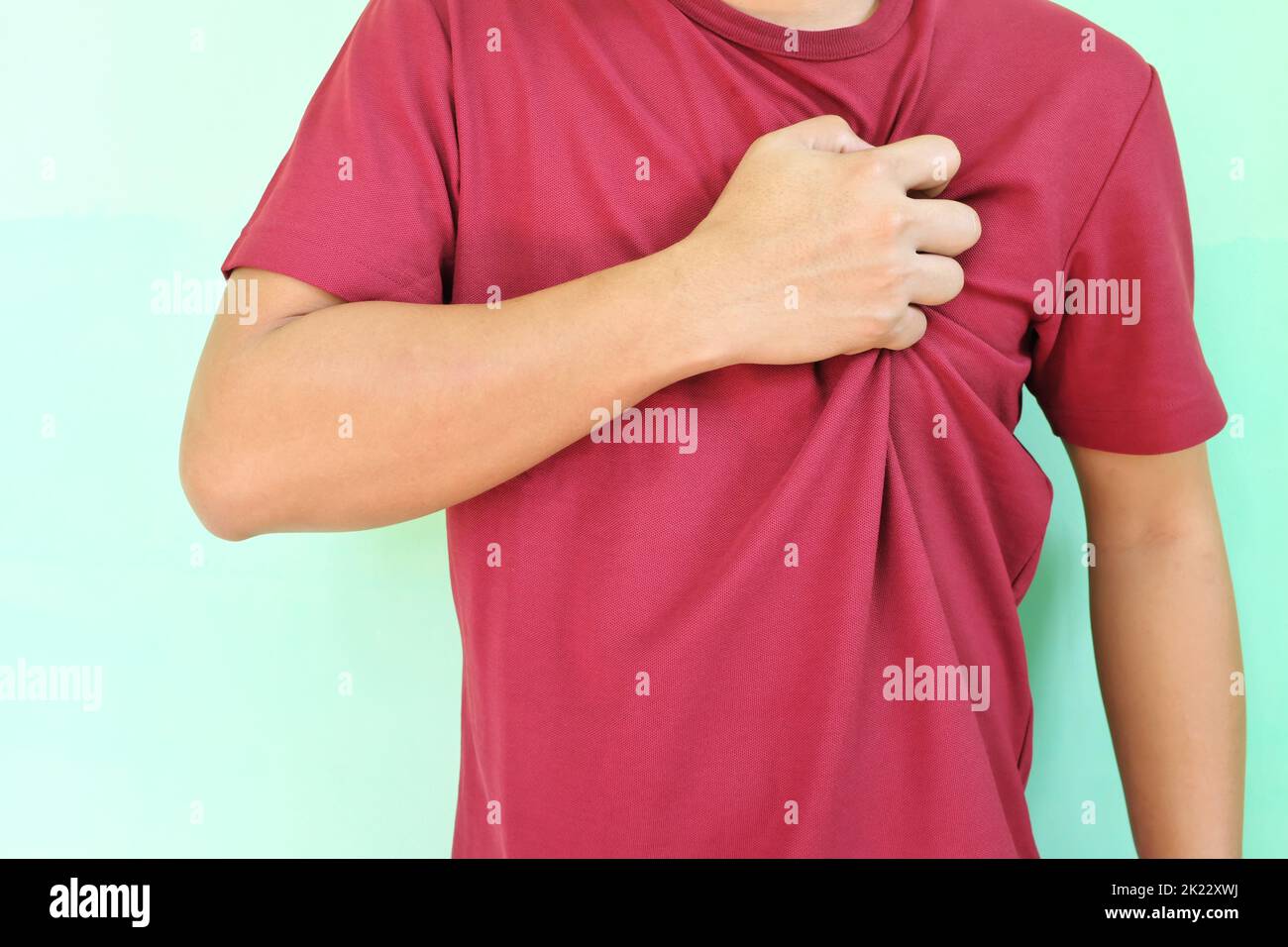 Heart pain, attack, ache, and heartburn concept. Young Asian man