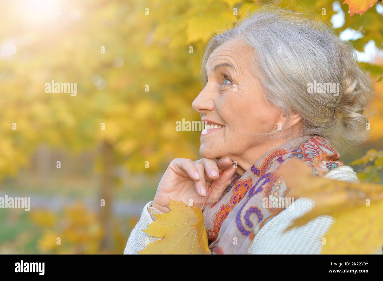 Senior woman walking in the park in autumn Stock Photo - Alamy