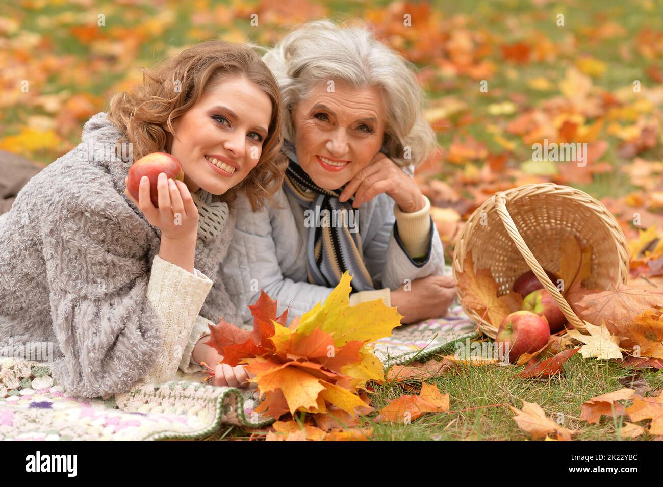 An elderly woman with her daughter lies in autumn. Stock Photo