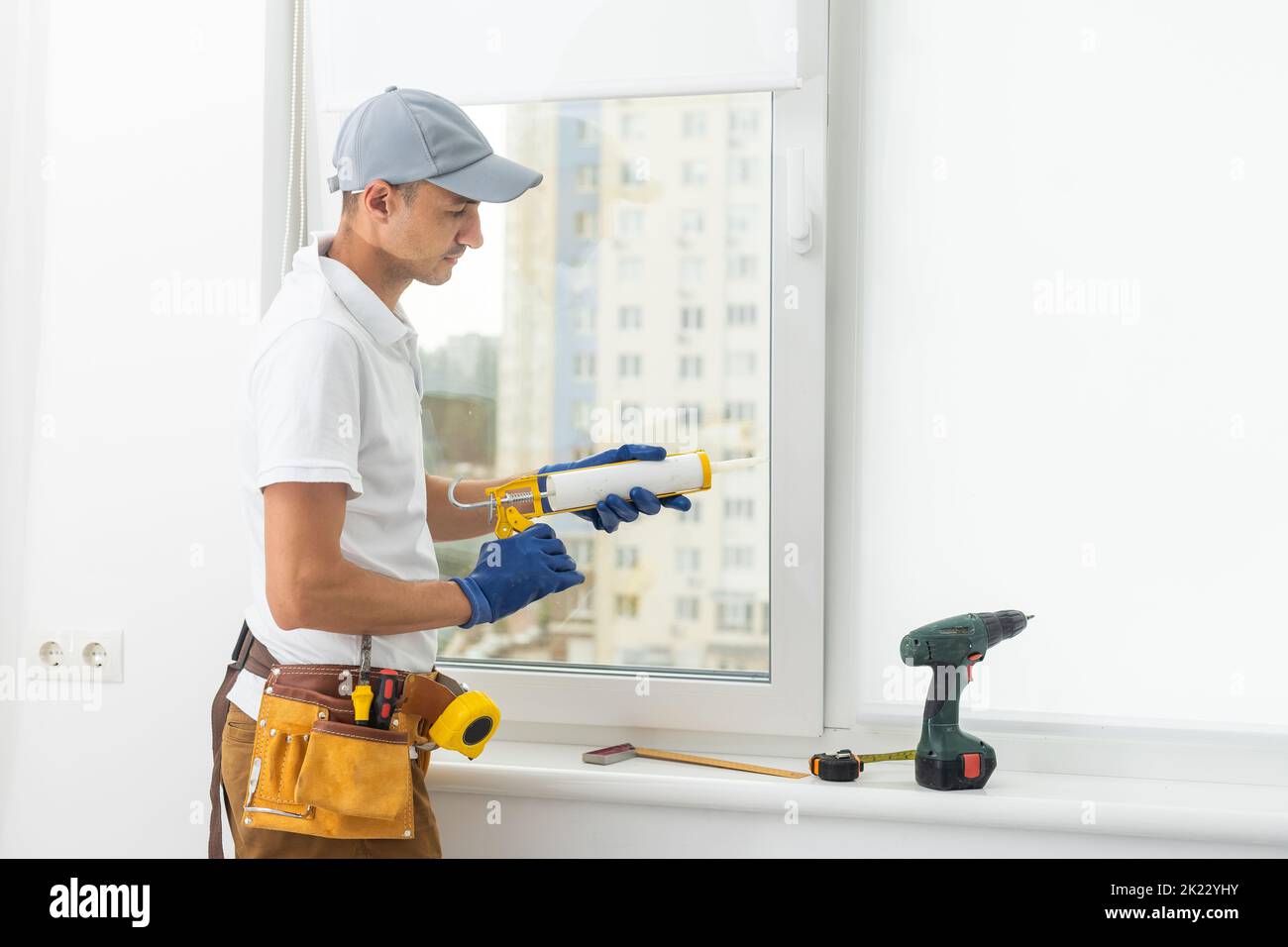 View of a repairman repairs, adjusts or installs metal-plastic windows in the ...