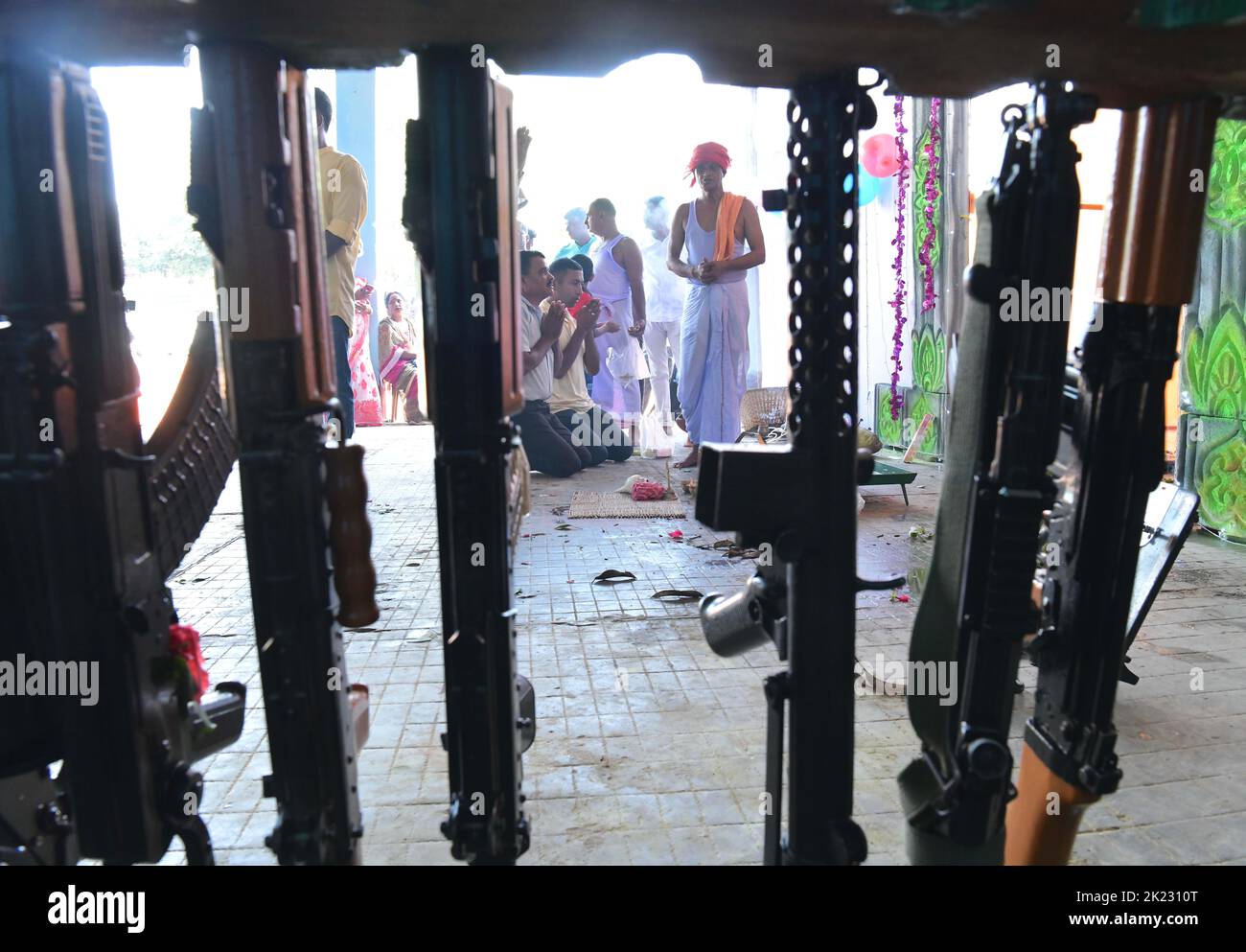 A priest blessing weapons belonging to TSR 2nd Battalion (Tripura State Rifles ) during the Vishwakarma Puja festival, a Hindu God, the divine architect, in the TSR camp on the outskirts of Agartala. Tripura, India. Stock Photo