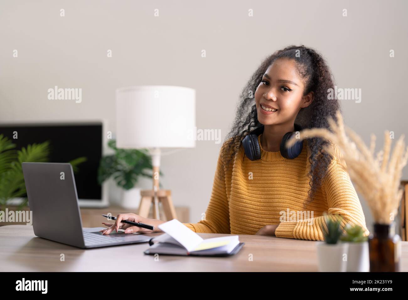 Young woman using laptop computer at office. Student girl working at home. Work or study from home, freelance, business, lifestyle concept Stock Photo